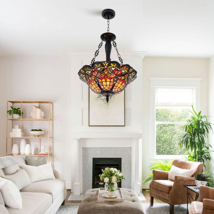 a living room filled with furniture and a fire place under a stained glass chandelier