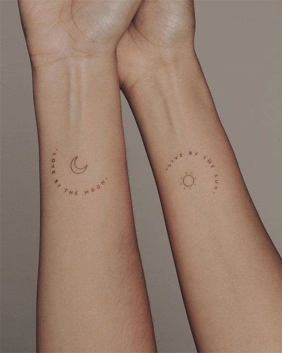 two wrist tattoos with the sun, moon and stars tattooed on each one side of their arms