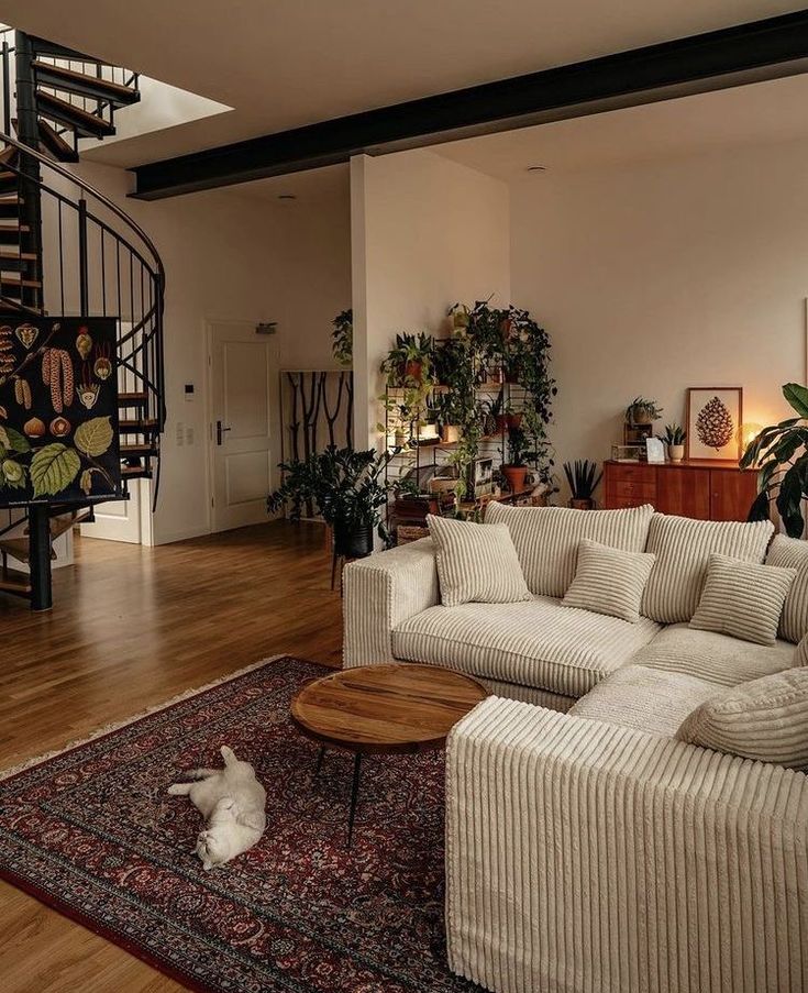 a living room filled with furniture and a spiral stair case in the center of the room