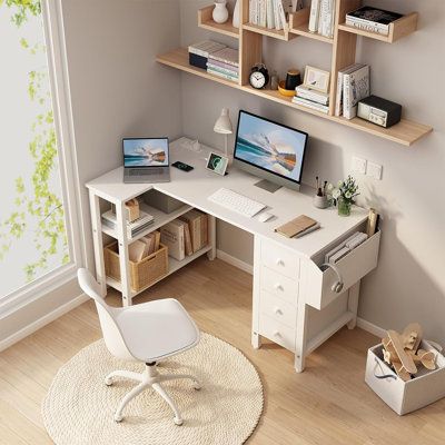 a computer desk with two computers on top of it next to a chair and bookshelf