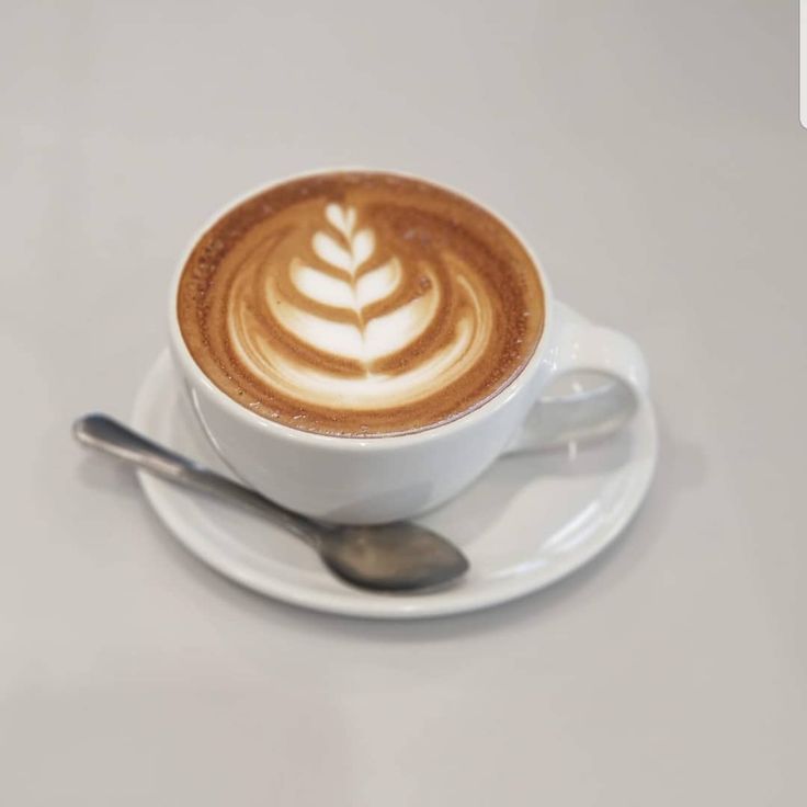 a cappuccino on a saucer with a spoon