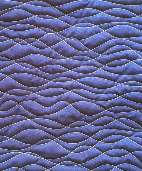 an image of a blue quilted material with wavy lines on the top and bottom