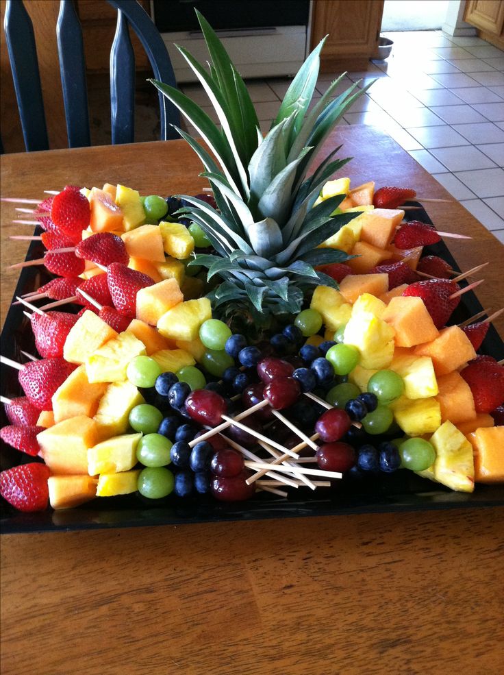 a fruit platter with pineapples, grapes, strawberries and pineapple