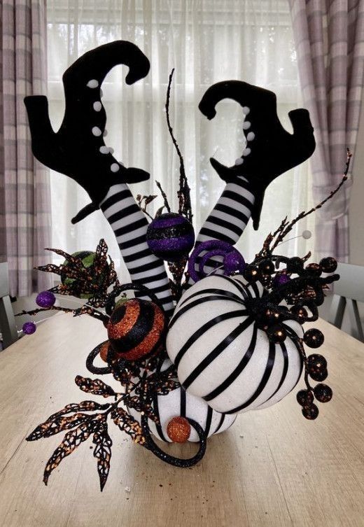 a table topped with halloween decorations on top of a wooden table next to a window