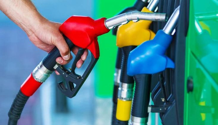 a person is pumping gas into their car at a gas station with fuel nozzles