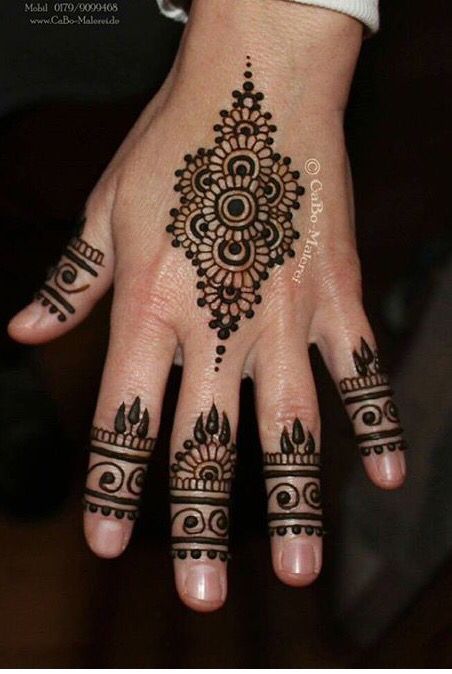 a woman's hand with henna tattoos on it