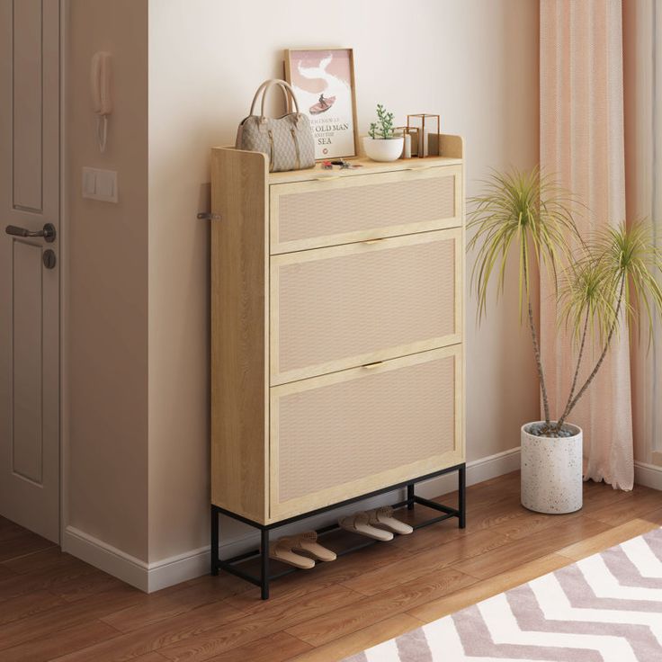 an empty room with a plant and pictures on the dresser