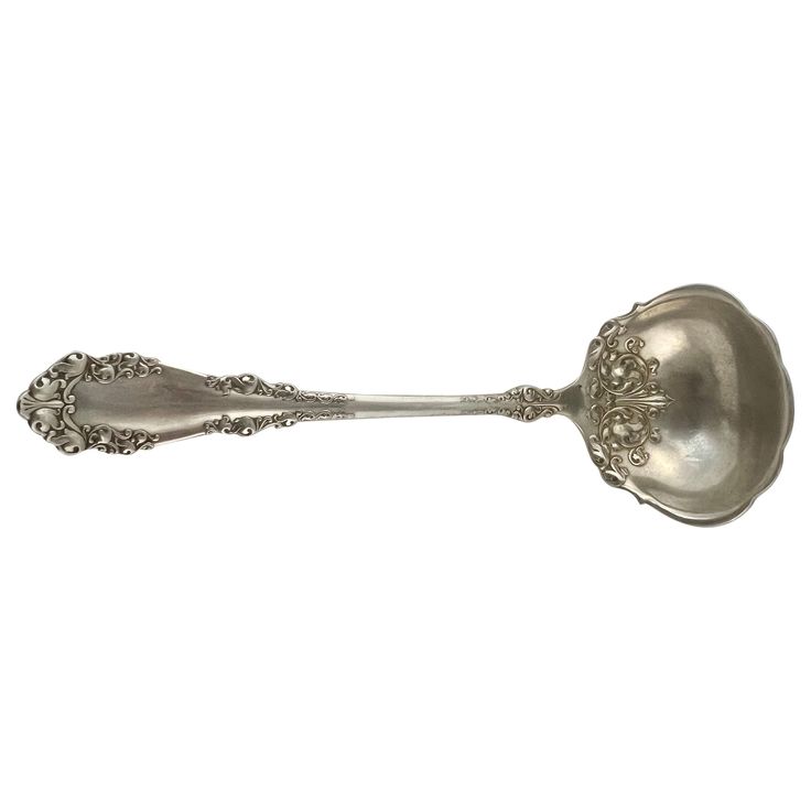 a silver spoon with ornate designs on it