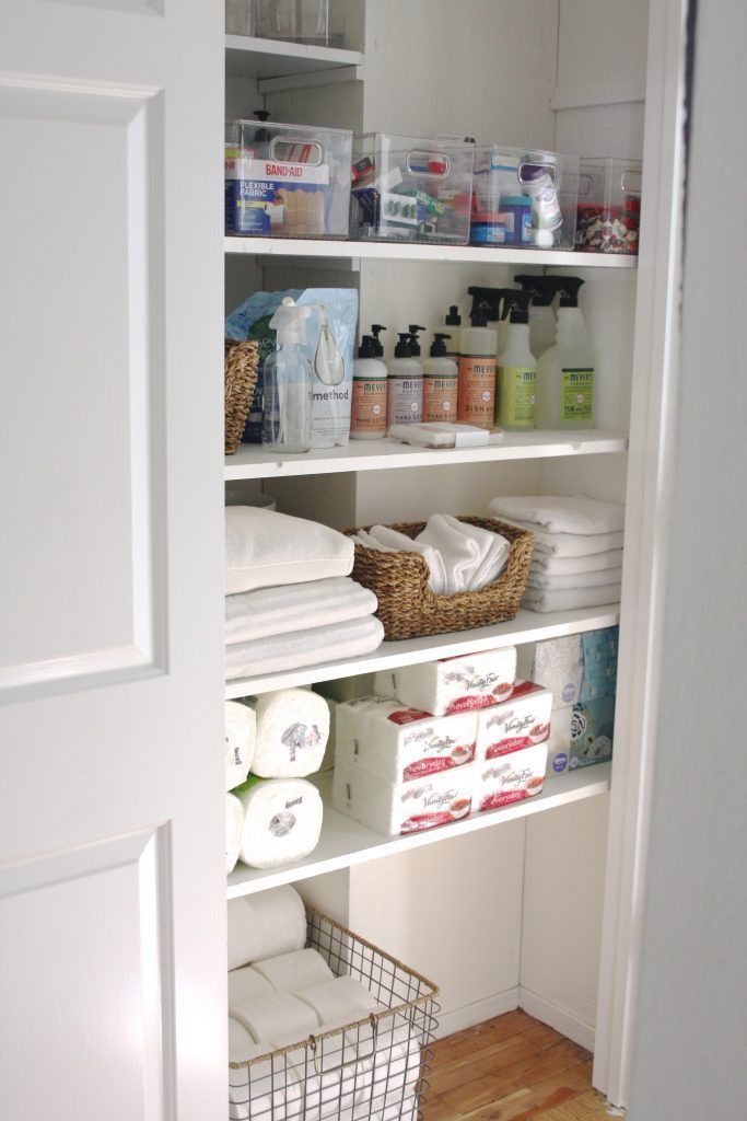 an organized pantry with white linens, toiletries and other items in baskets on the shelves