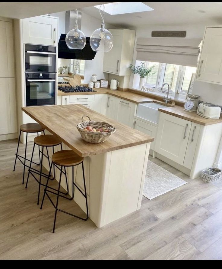 a large kitchen with an island in the middle and three stools at the end