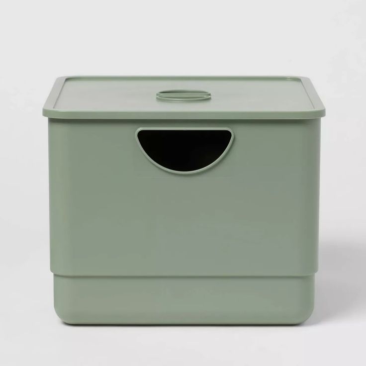 a green box with a hole in the middle and a lid on it's side