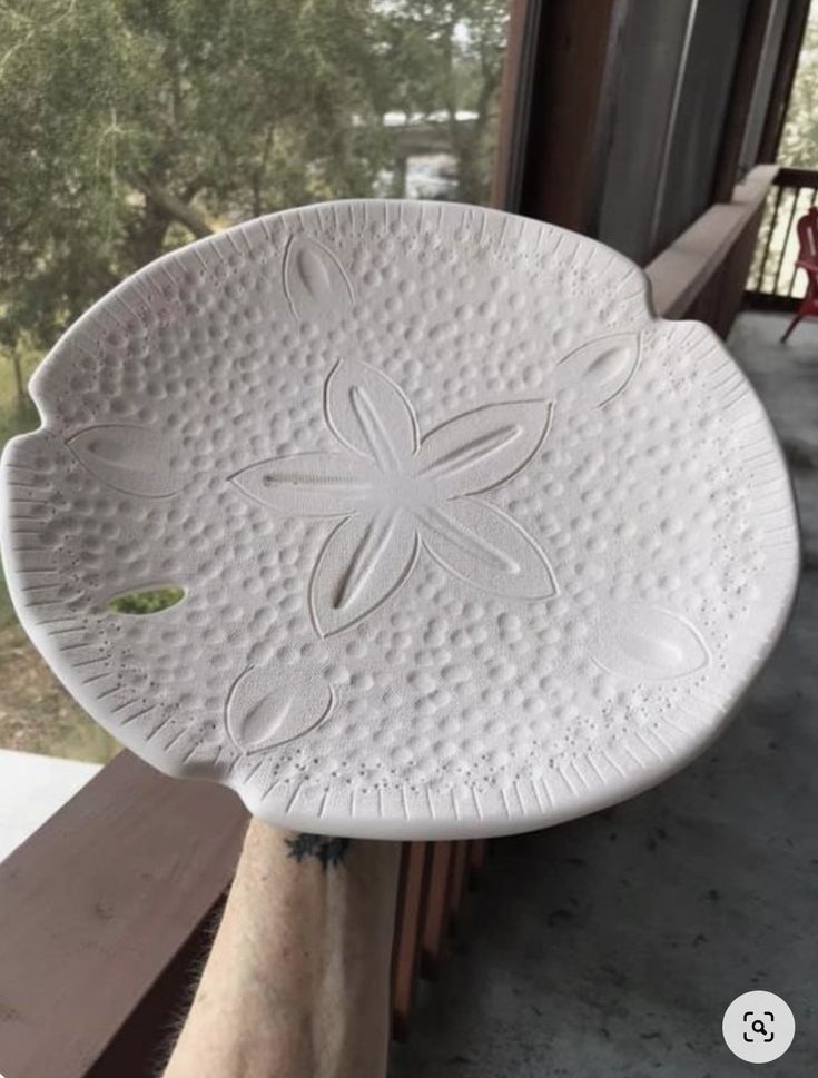 a white plate sitting on top of a window sill