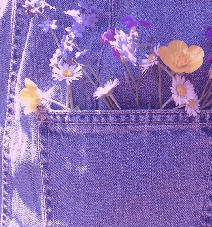 flowers are sticking out of the back pocket of a jean jacket