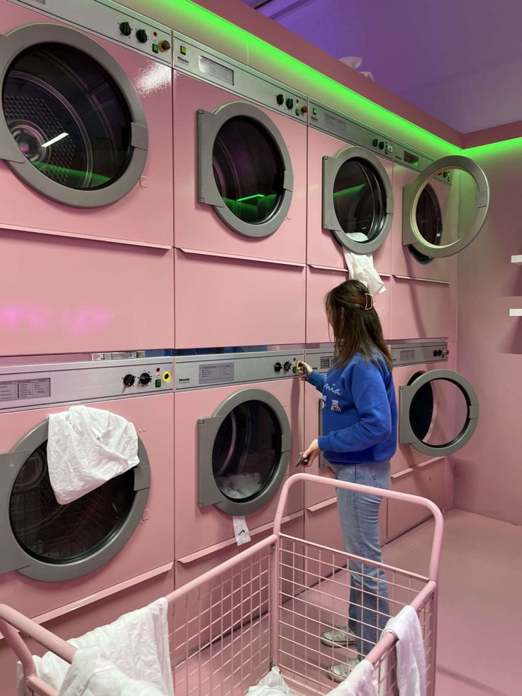 a woman standing in front of a row of washers