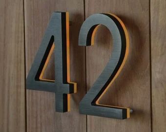 the number 42 is made out of metal and has an orange stripe on it's side