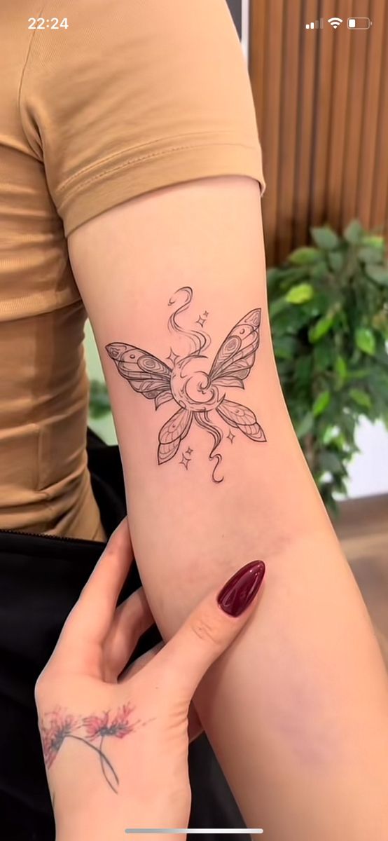 a woman's arm with a small tattoo on the back of her left arm