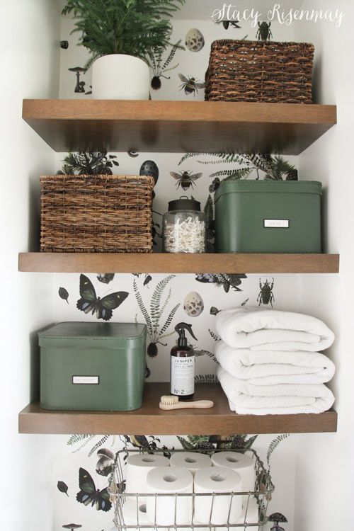 the shelves in this bathroom are filled with towels, baskets and other things to put on them