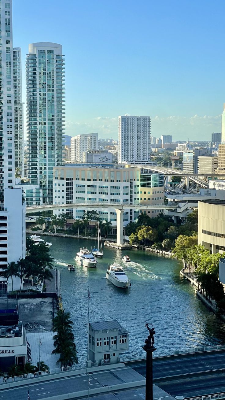 boats are in the water near tall buildings