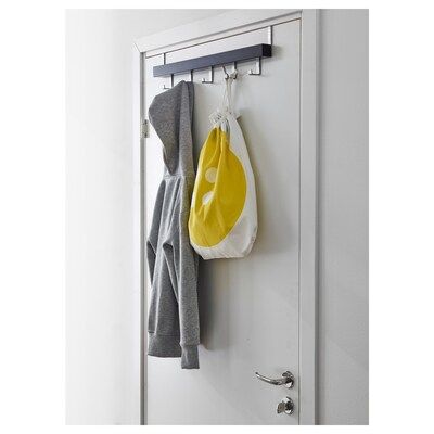 a coat rack with two coats hanging from it's hooks and a bag on the door handle