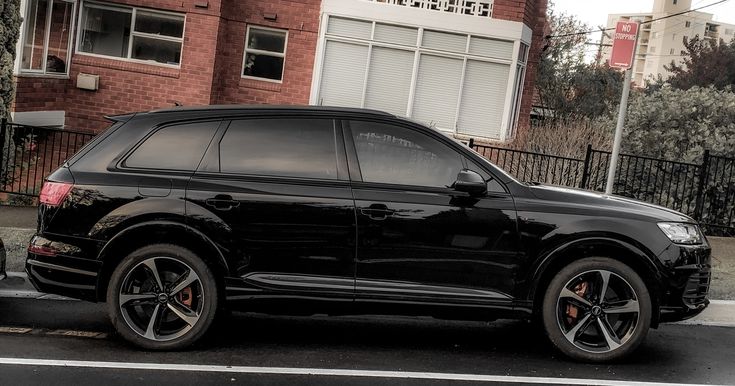 a black suv parked in front of a red brick building