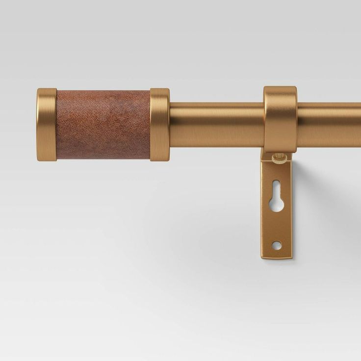 an image of a gold curtain rod with wooden handle on a white background, close up