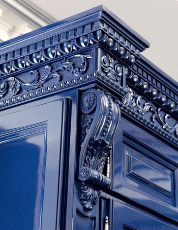 a blue cabinet with ornate carvings on it