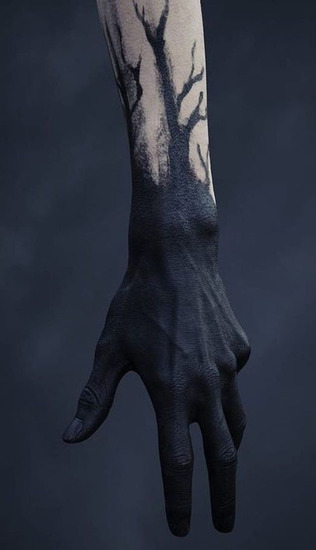 a person's hand with a tree painted on the arm and wrist, against a dark background