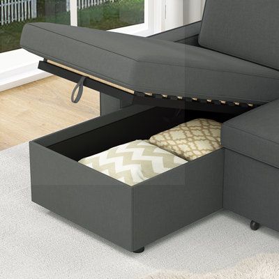 a grey couch with storage underneath it