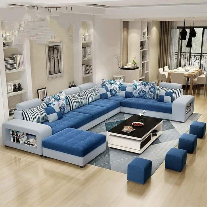 a blue and white sectional sofa in a living room with lots of pillows on it