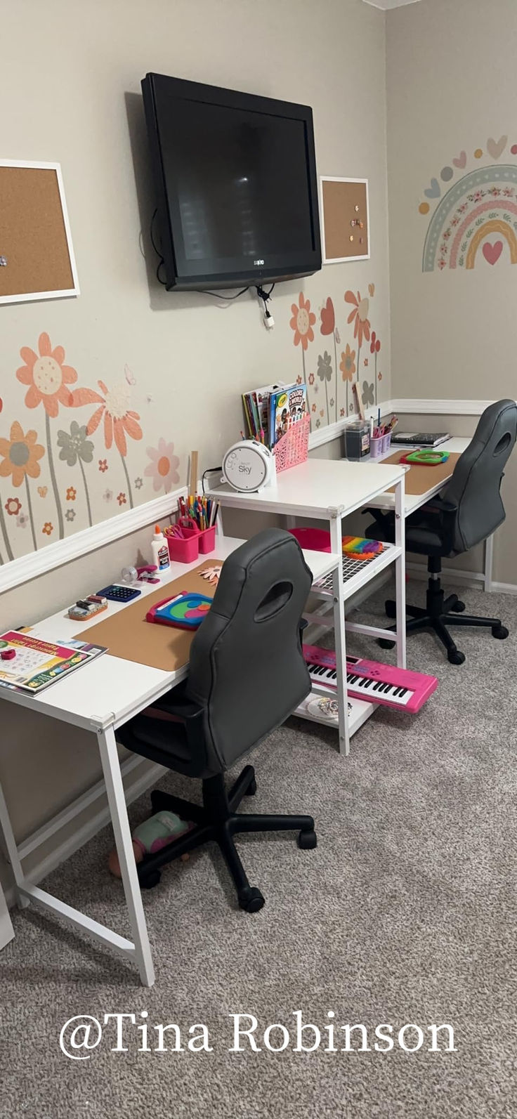 a room with two desks and a television on the wall