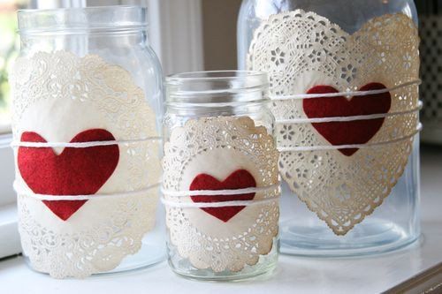 three mason jars decorated with red and white heart doily, one has a lace border around the top