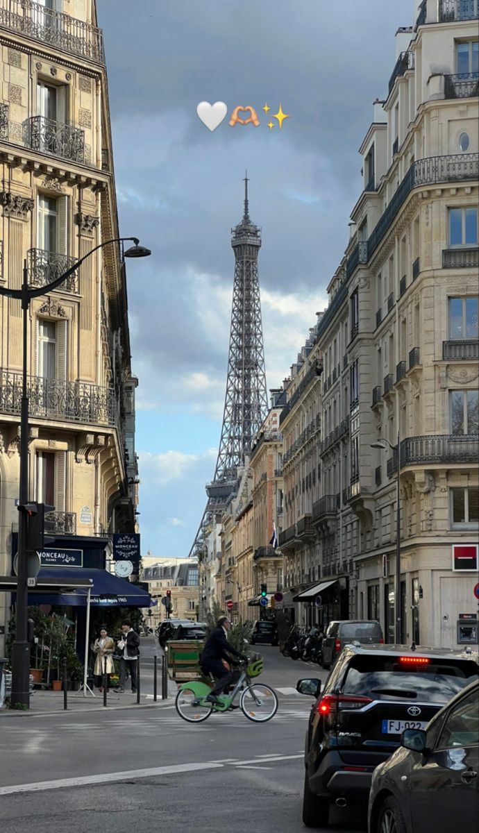 the eiffel tower is in the distance as people ride bikes down the street