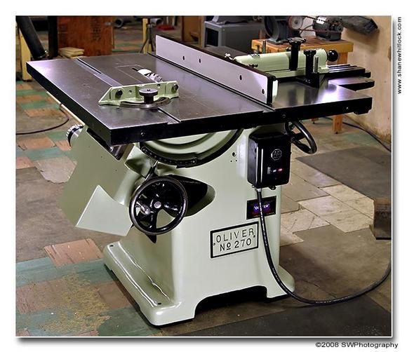 a table sawing machine sitting on top of a hard wood floor in a shop