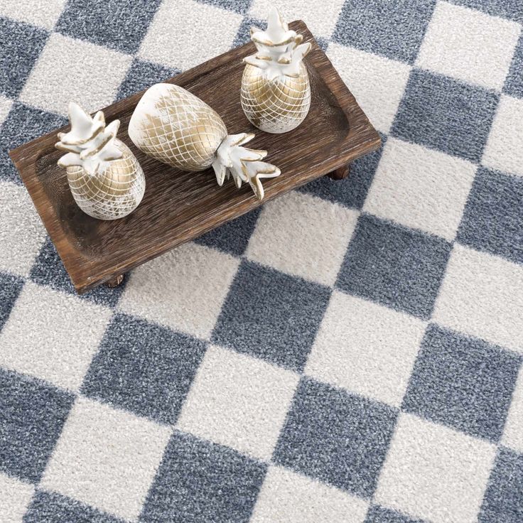 two sea urns sitting on top of a wooden tray in the middle of a checkered floor