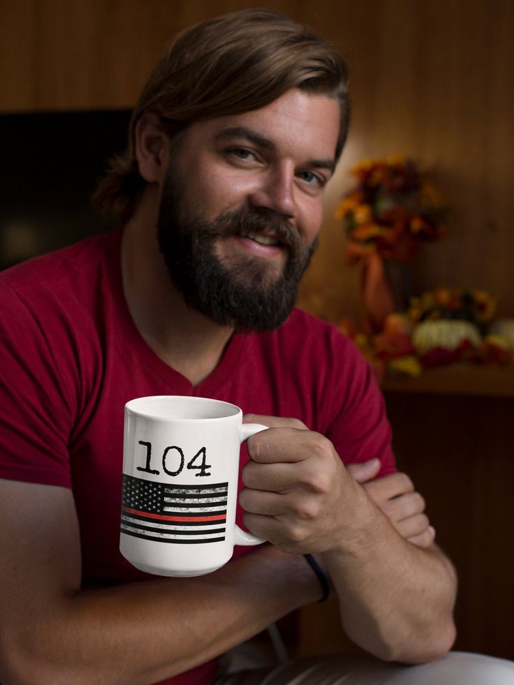 a man with a beard is holding a coffee mug