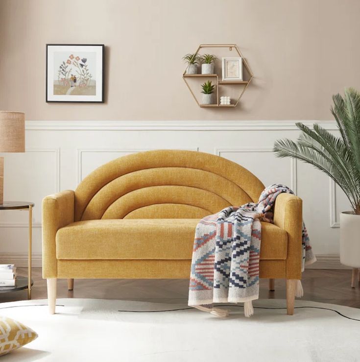 a living room with a yellow couch and potted plants on the side table in front of it