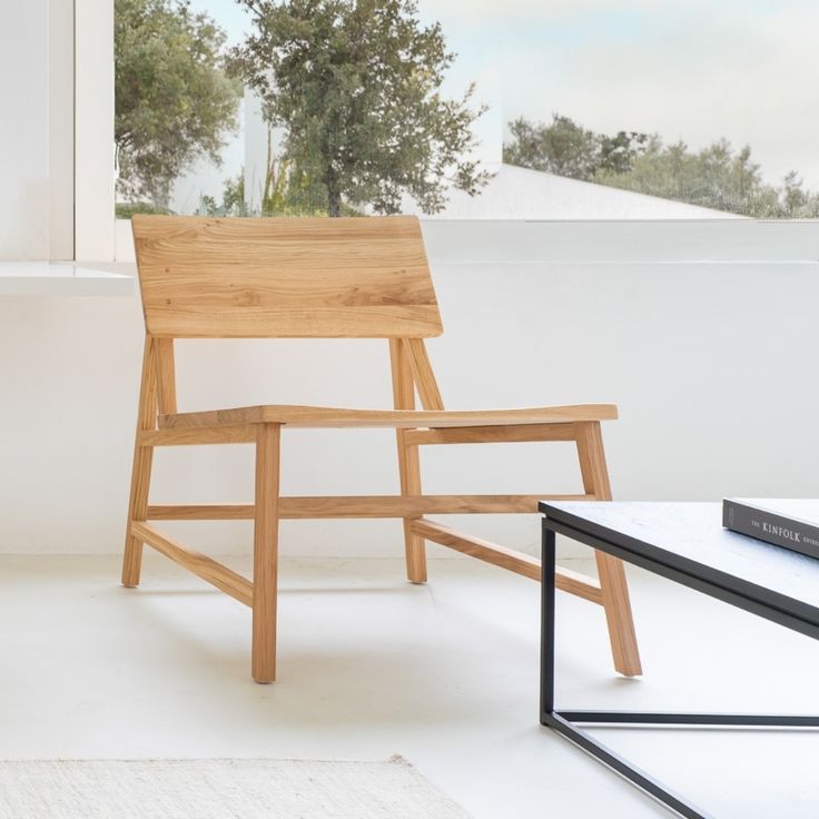 a wooden chair sitting in front of a window