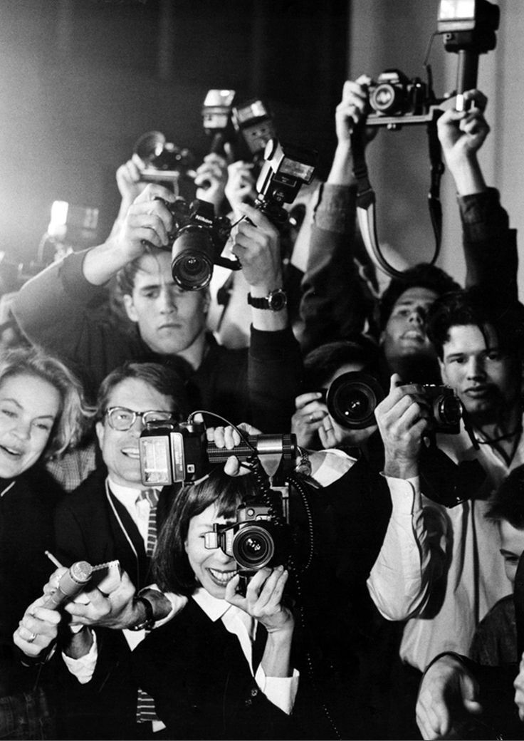 a group of people taking pictures with cameras