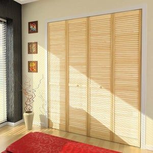 an empty room with wooden blinds on the windowsill and red rug in front of it