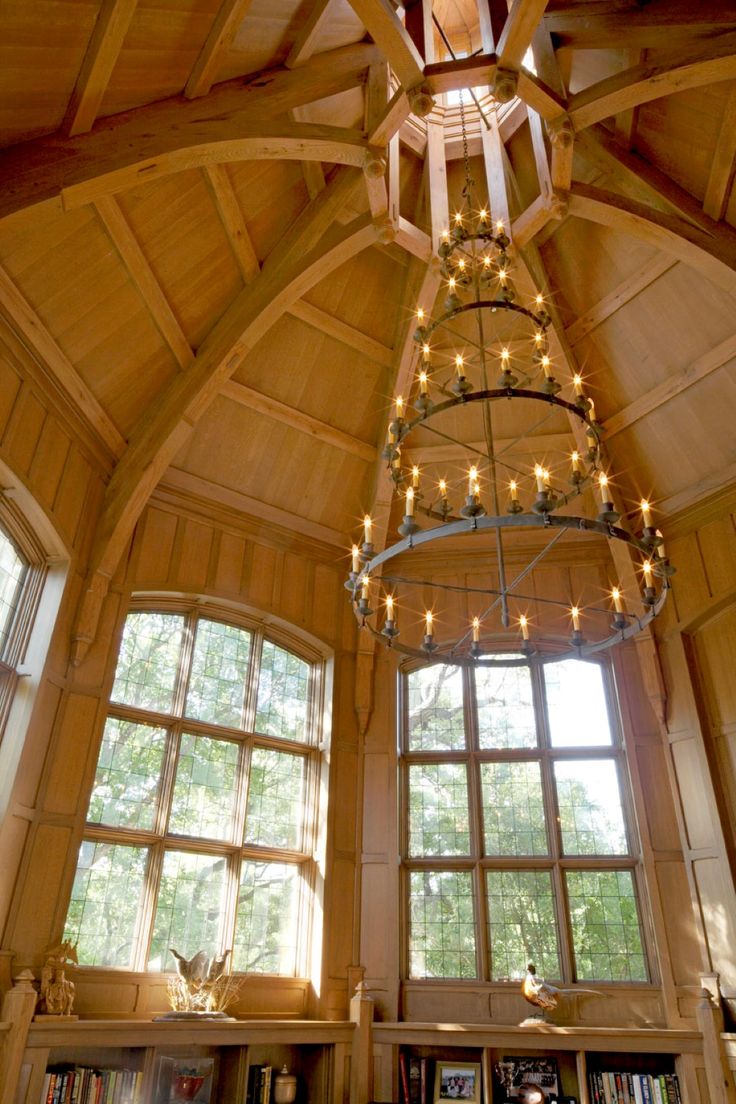 a living room filled with lots of furniture and large windows covered in string lights next to a fire place