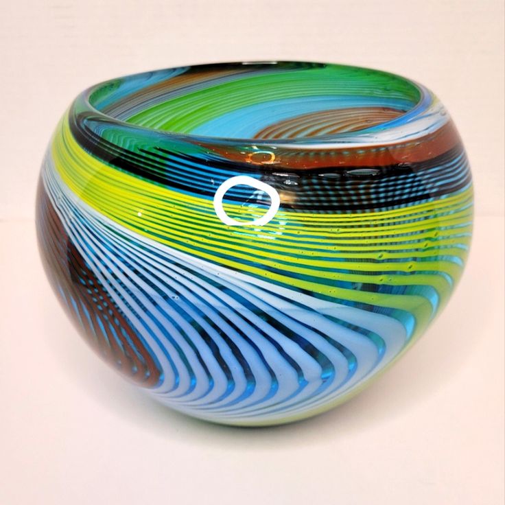 a colorful glass bowl sitting on top of a table