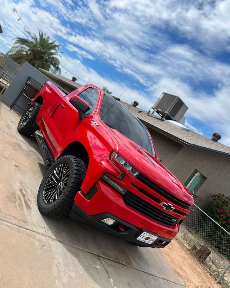 a red truck parked in front of a house