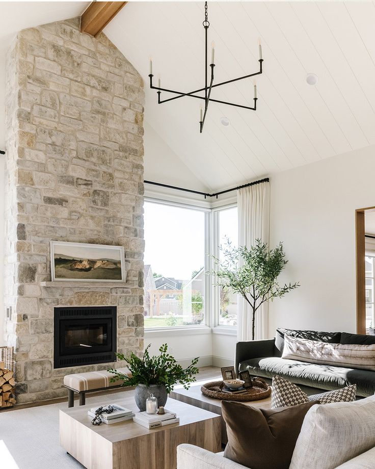 a living room filled with furniture and a fire place in front of a stone fireplace