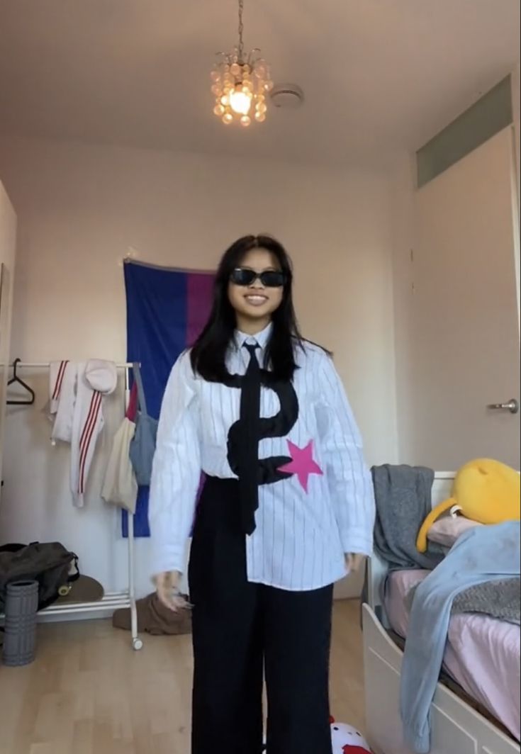 a woman standing in a room wearing sunglasses and a shirt with the number nine on it