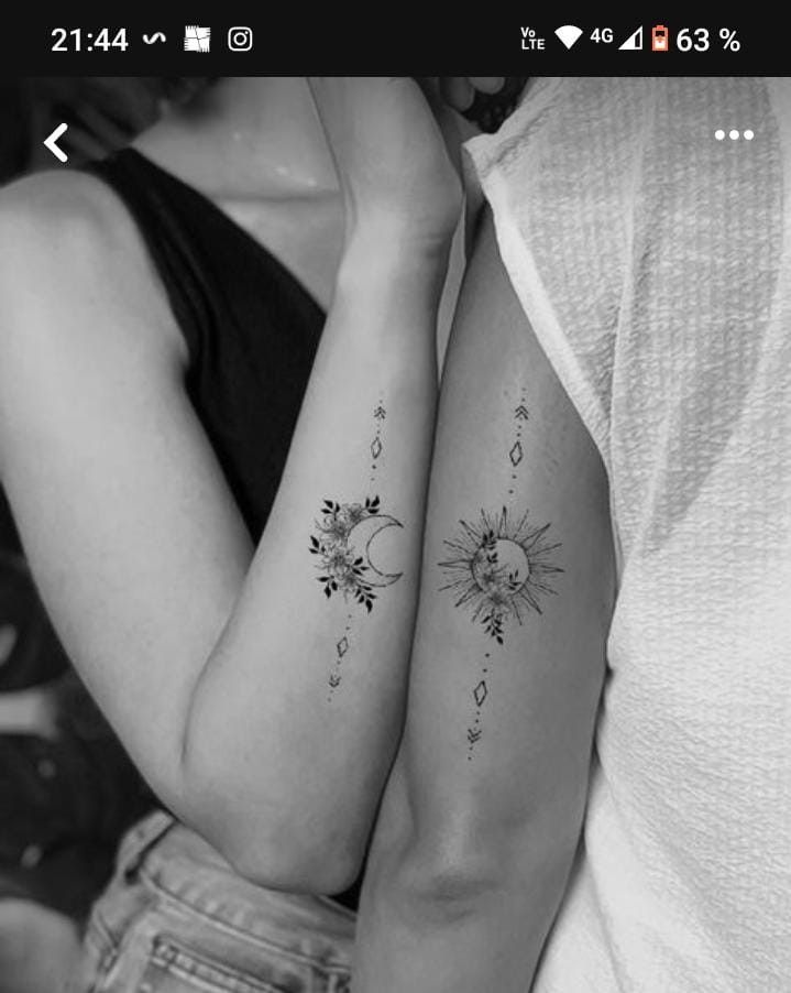 two women with tattoos on their arms and one is holding the other's arm