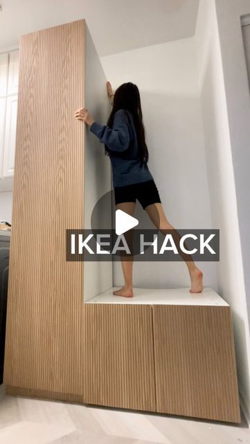 a woman standing on top of a wooden shelf