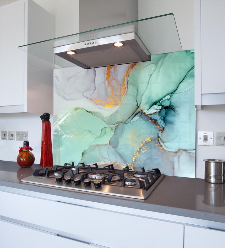 a stove top oven sitting inside of a kitchen next to a wall covered in marble