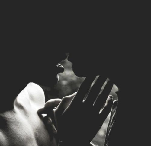 a man and woman kissing in the dark with their hands on each other's shoulders