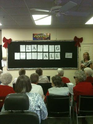 a group of people sitting in front of a blackboard with words written on it