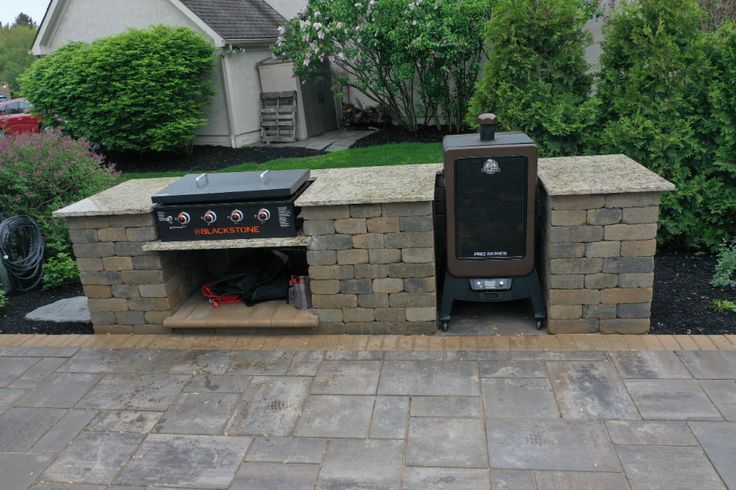 an outdoor bbq grill in the middle of a driveway